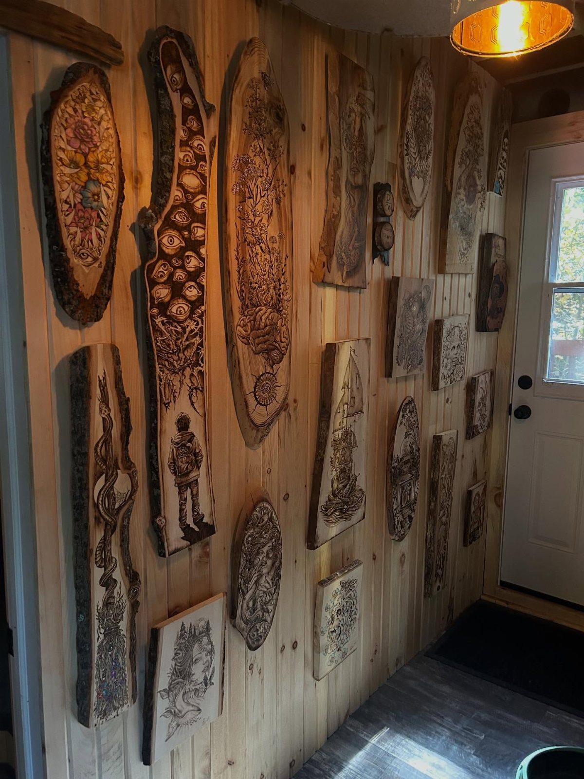 Art in Wood: 8 Ideas, From Knot Jewelry to Totem Pillars 8 Carved and burned wooden art pieces displayed on a light wood paneled wall.