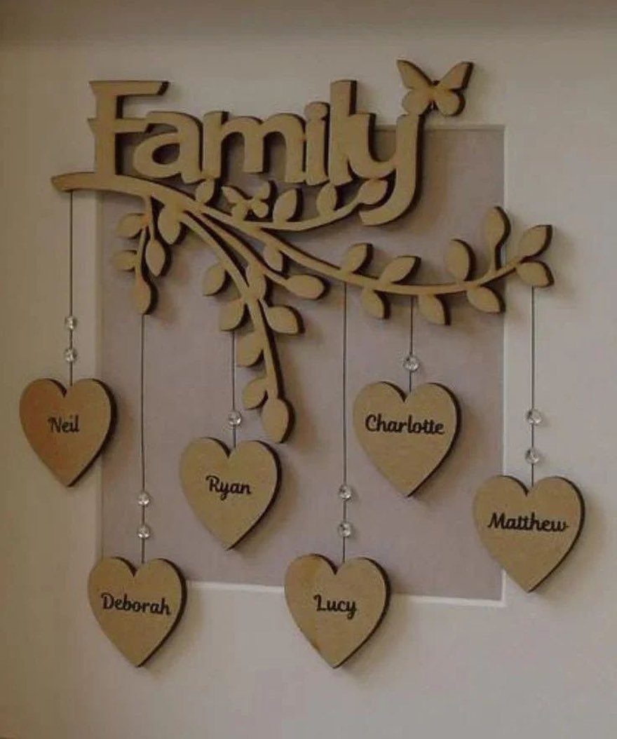 Art in Wood: 8 Ideas, From Knot Jewelry to Totem Pillars 2 Wooden family wall art with a branch and heart pendants engraved with names.