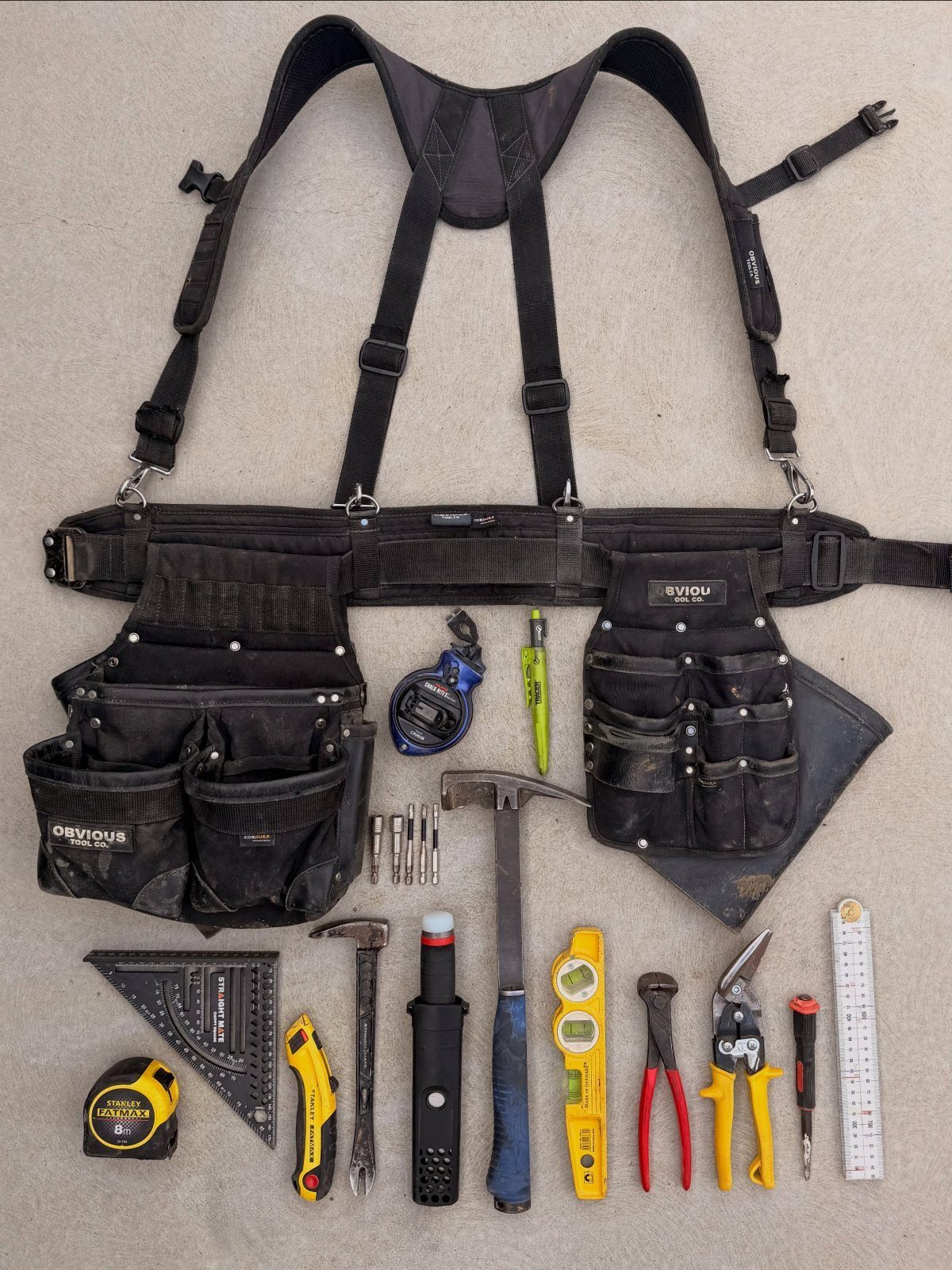 13 Carpentry Tools and Equipment for Every Workshop 7 Carpentry tool set featuring a black tool belt and various hand tools on grey background.