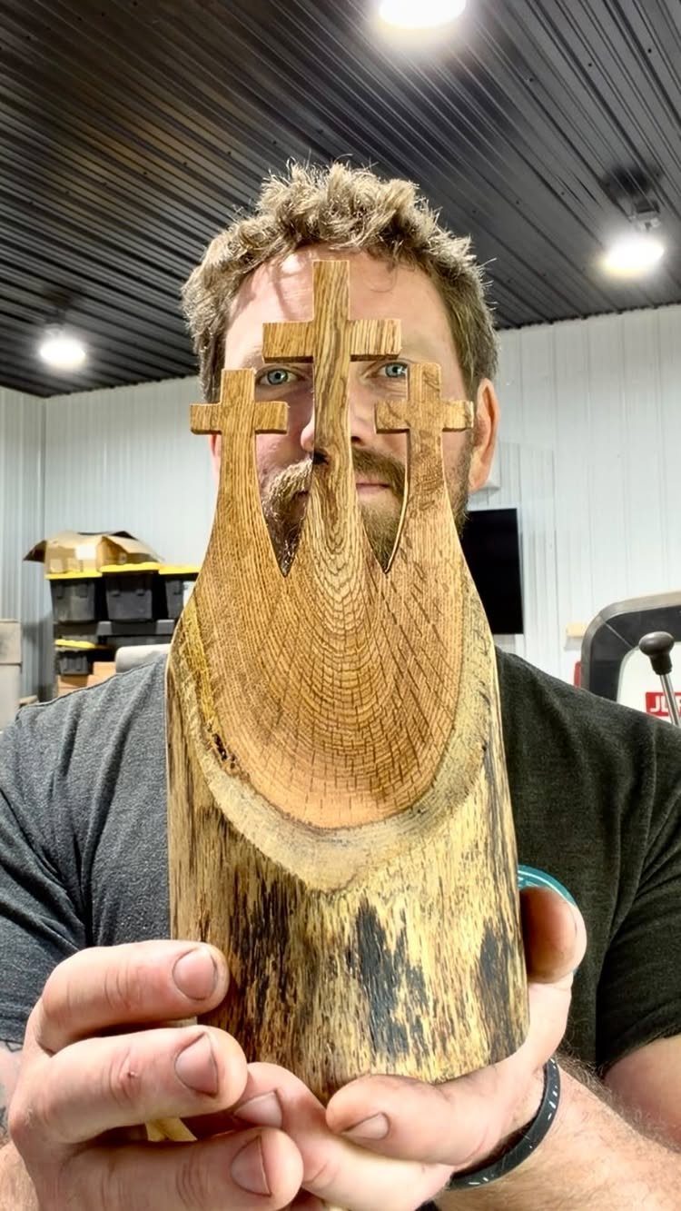 Christian Woodworking Projects: 9 Ideas for Home and Gifts 8 Carved wooden piece with three Christian crosses held by a man in a workshop.