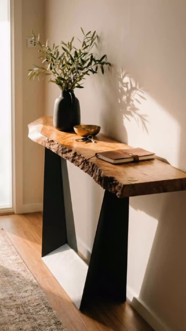 Creative Wood Designs: 8 Ideas for Furniture and Decor 6 Live-edge wooden console table with black metal legs and a vase of olive branches.