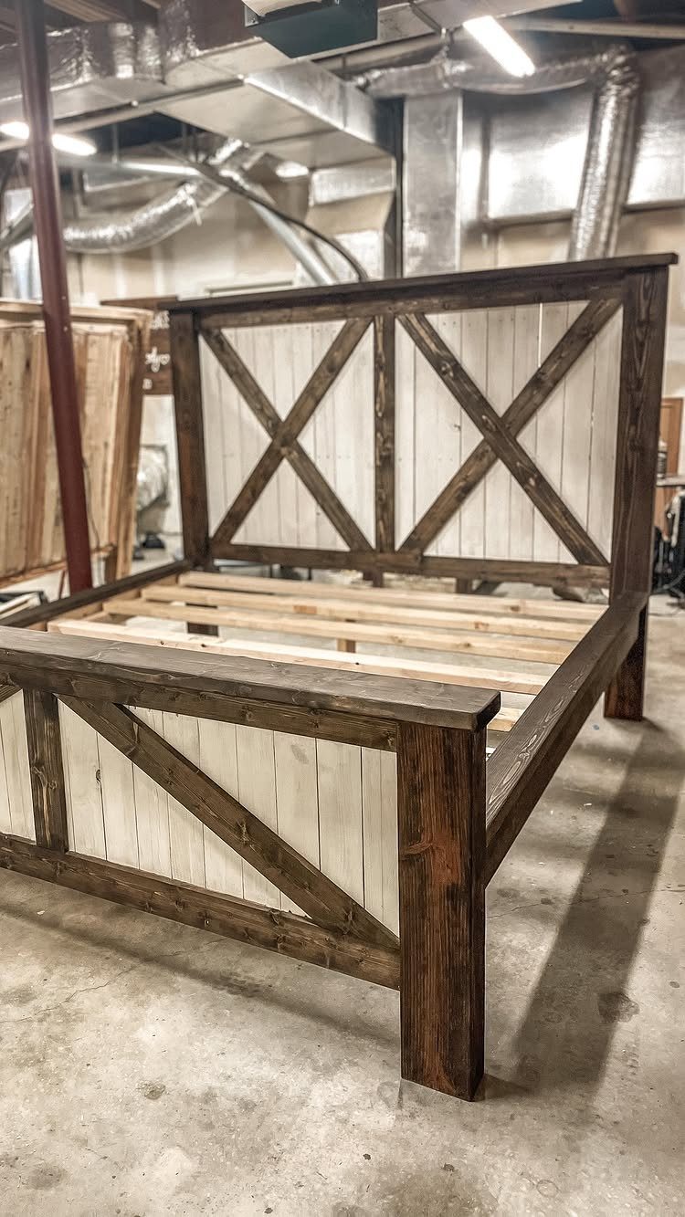 Wooden bed frame with dark brown trim and white X-shaped paneled headboard and footboard.