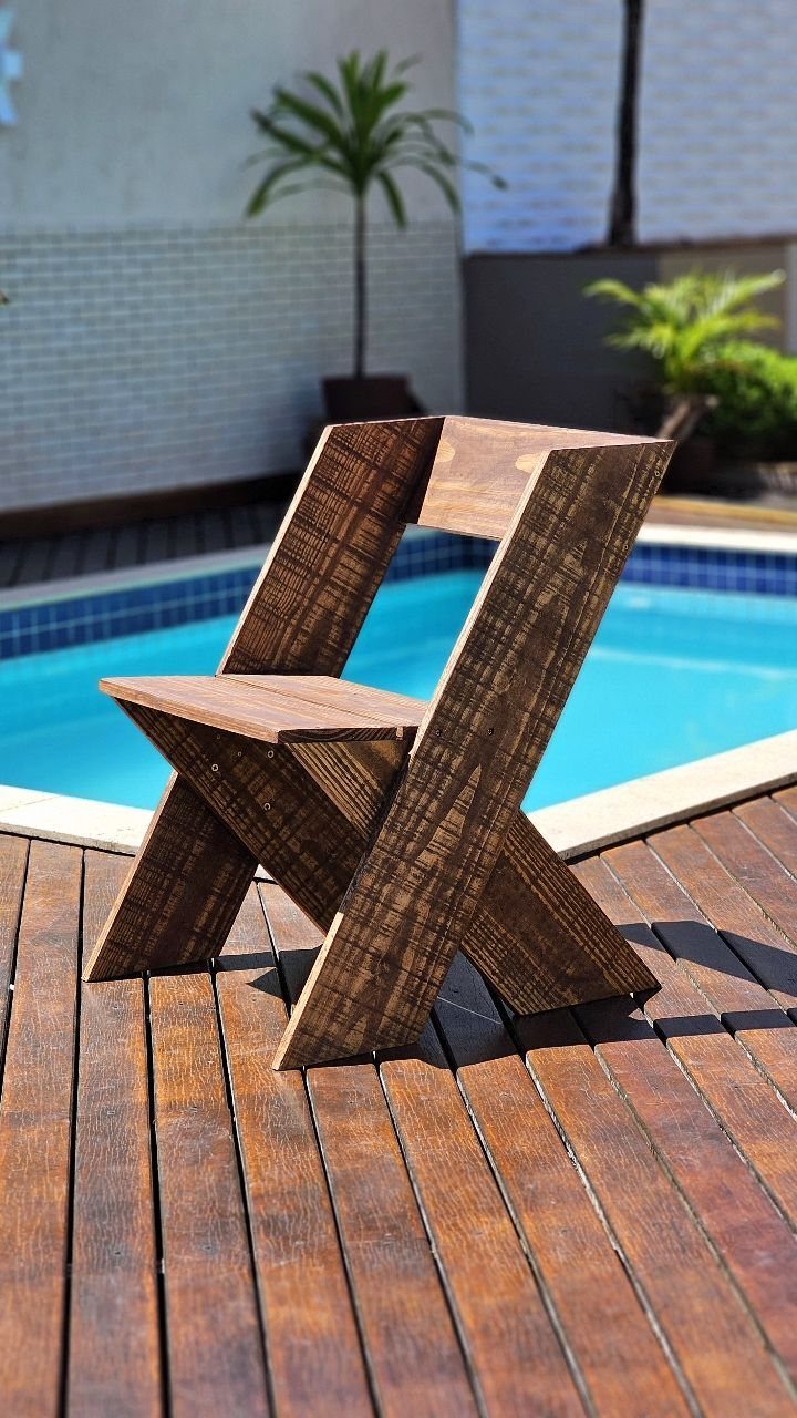 10 DIY Outdoor Chair Ideas for Patios, Porches and Decks 7 Geometric dark brown wooden chair on a poolside deck with a blue swimming pool.