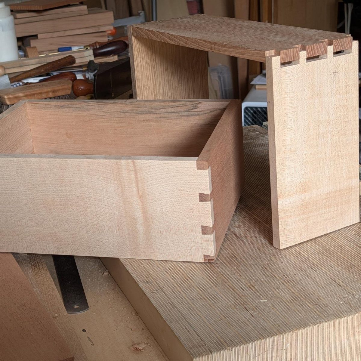 How to Build a DIY Treasure Chest With Wood: 12 Ideas 1 Two light-colored wooden boxes with interlocking box joints on a woodworking workbench.