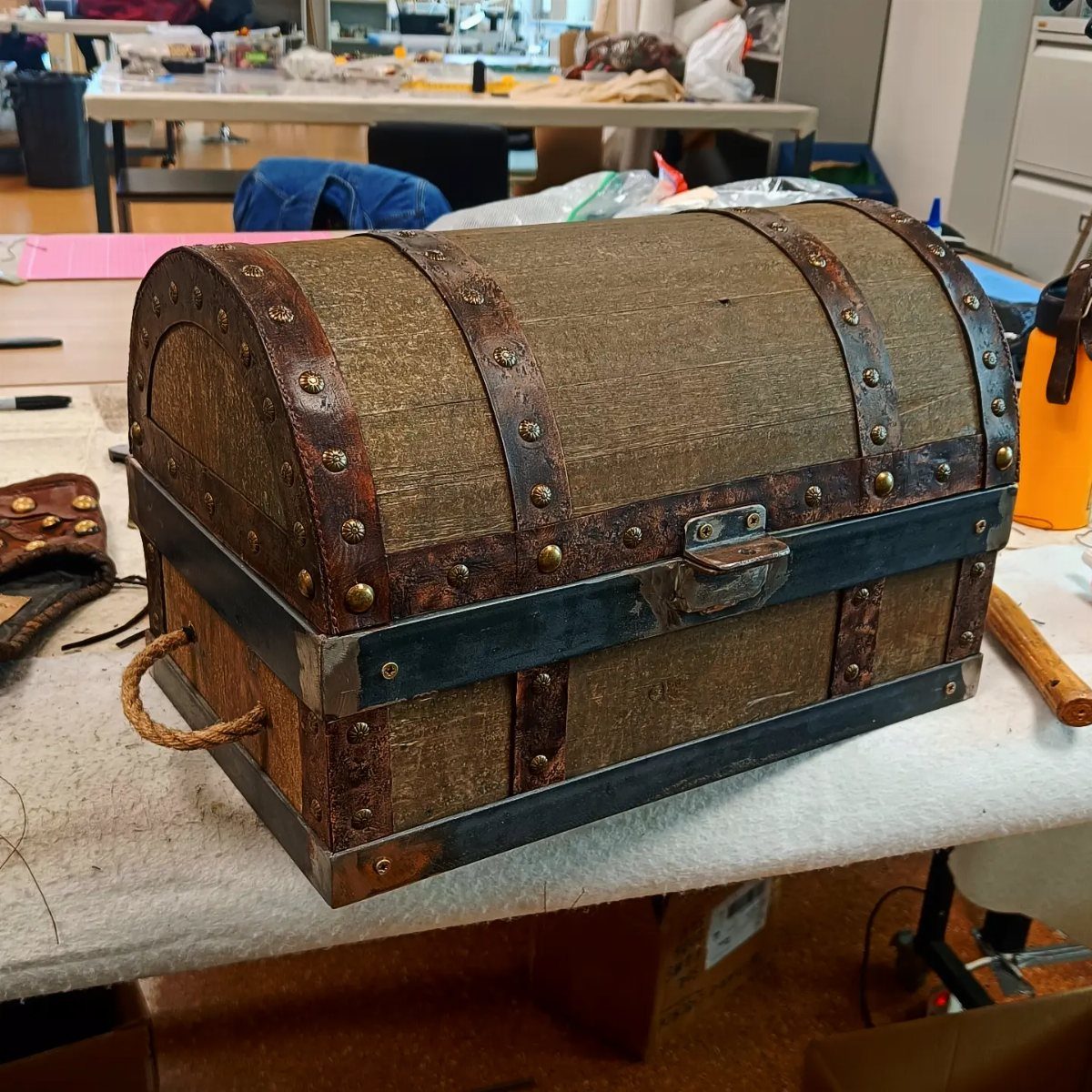 How to Build a DIY Treasure Chest With Wood: 12 Ideas 3 Handmade wooden treasure chest with metal bands and rope handles on a table.