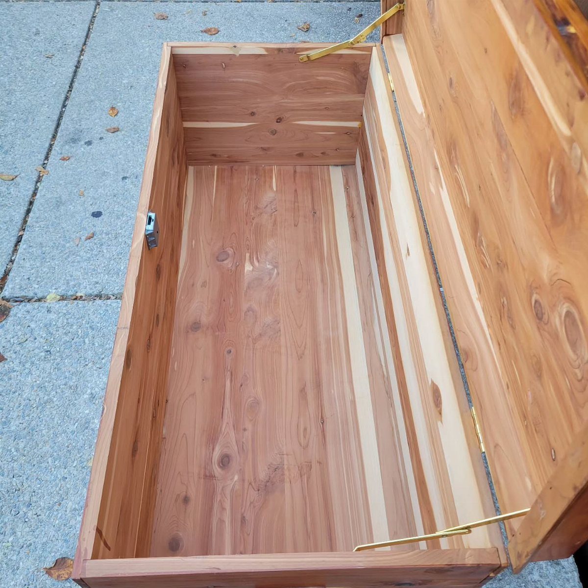 How to Build a DIY Treasure Chest With Wood: 12 Ideas 8 Open wooden cedar treasure chest with gold hinges on a concrete ground