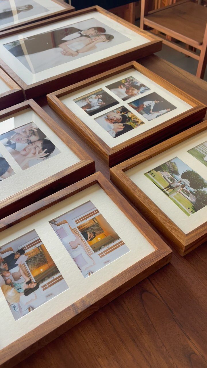 16 DIY Wooden Projects for Home, Garden, and Holiday Decor 1 Wooden picture frames with white mats and photos resting on a dark wood table.