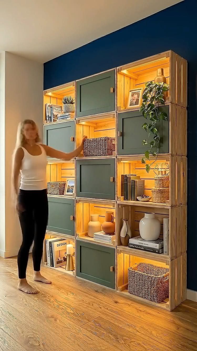 16 DIY Wooden Projects for Home, Garden, and Holiday Decor 9 Wooden crate shelving unit with green doors and decorative items against a blue wall.