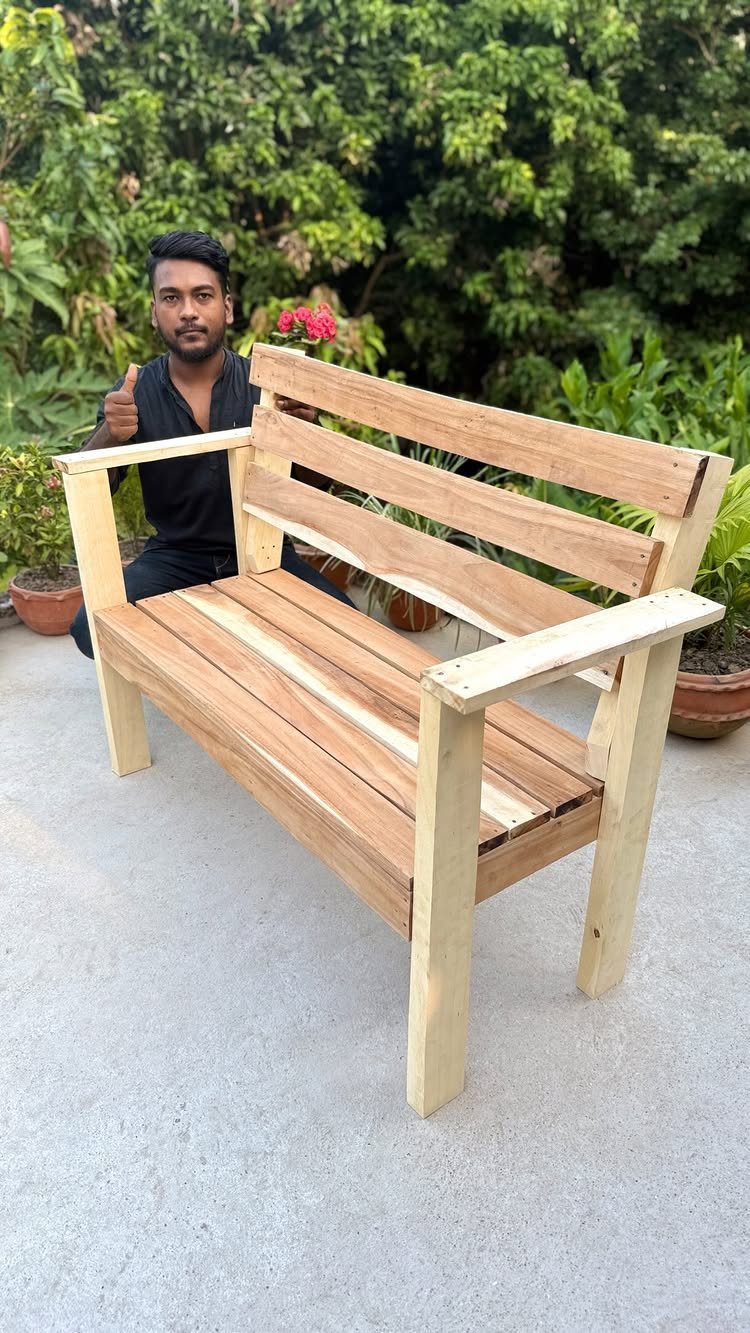 16 DIY Wooden Projects for Home, Garden, and Holiday Decor 5 Wooden garden bench with a slatted design and a man posing behind it.