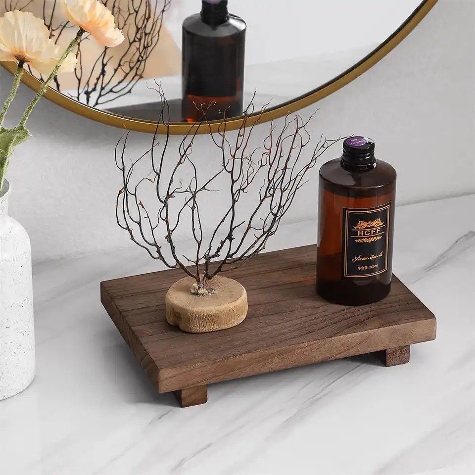 6 DIY Wooden Riser Ideas for Plants, Kitchens and Decor 6 Square dark brown wooden riser holding a decorative branch and a brown glass bottle.