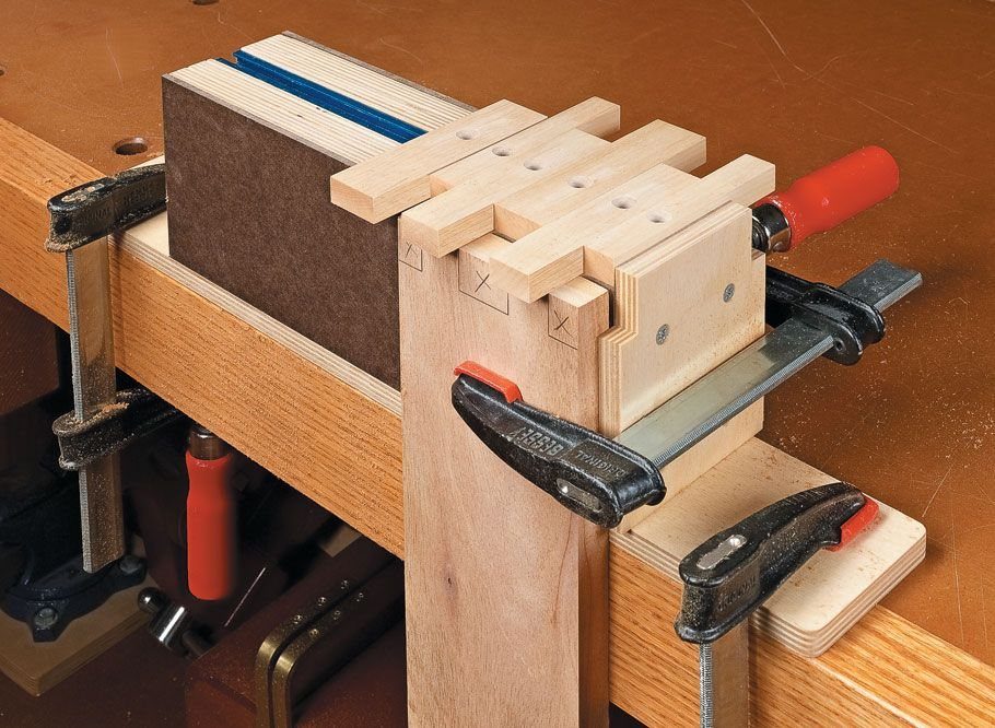 Finger Joints Woodworking: 4 Ideas for Strong Corners 2 Wooden boards with finger joints being held together by metal clamps on a workbench.