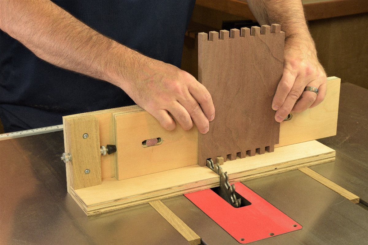 Finger Joints Woodworking: 4 Ideas for Strong Corners 4 Wooden board being cut with finger joints using a table saw jig