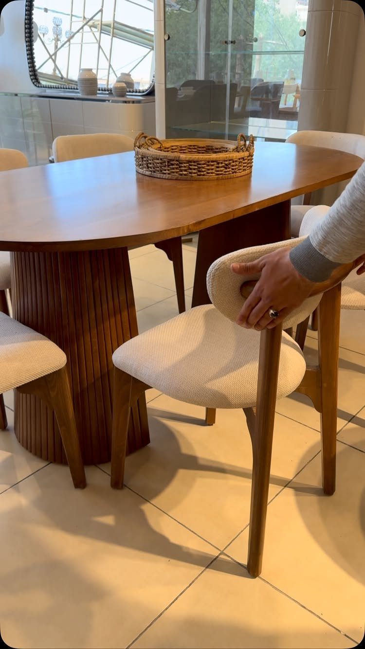 Furniture Design with Wooden Details: 9 Ideas for Home 7 Oval wooden dining table with ribbed base and cream upholstered chairs in a room.