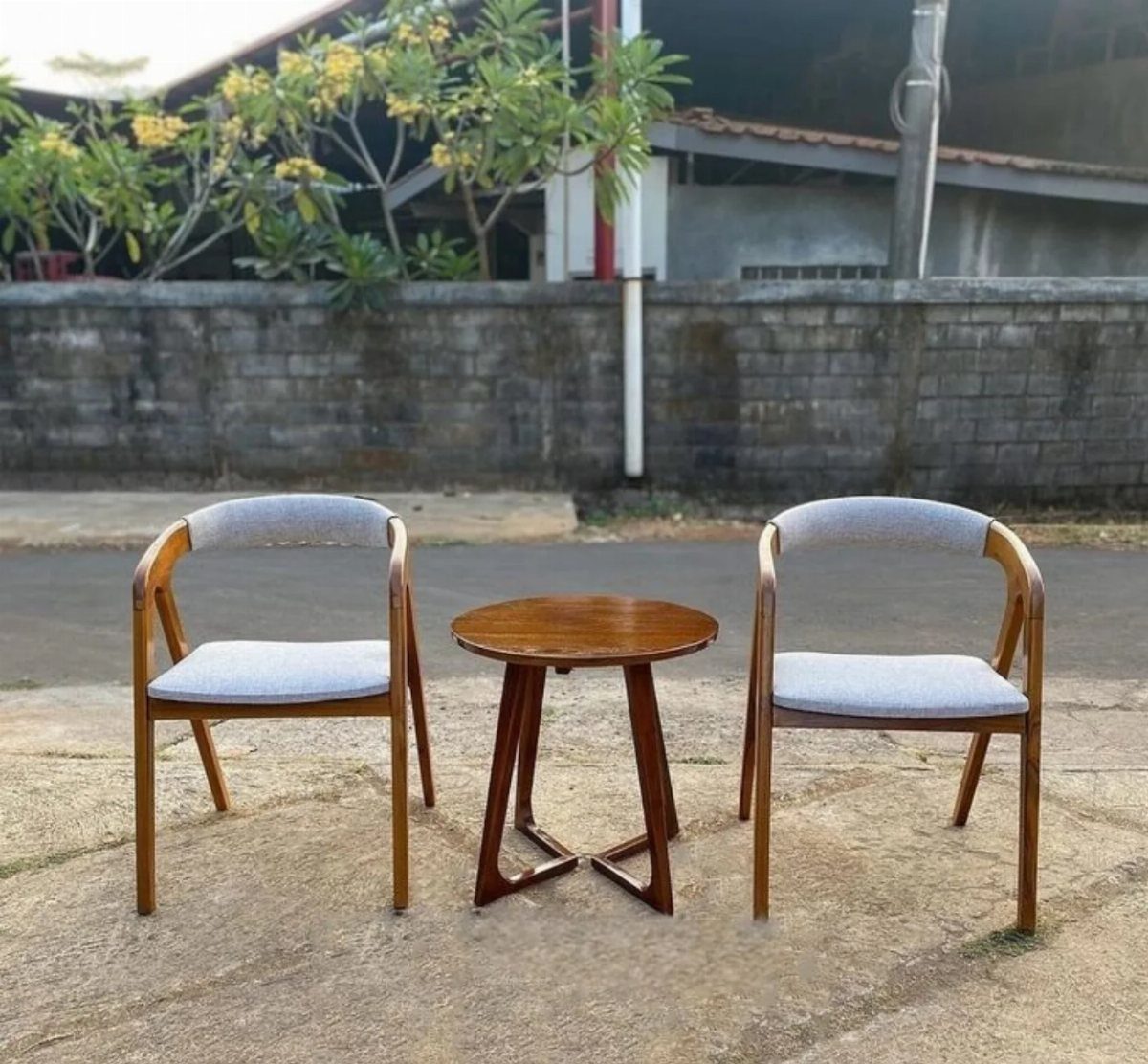 Furniture Design with Wooden Details: 9 Ideas for Home 1 Two wooden armchairs with grey cushioned seats and a small round wooden table.