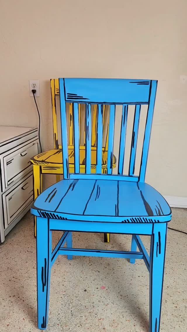Blue and yellow wooden chairs painted with black outlines in a comic book style.