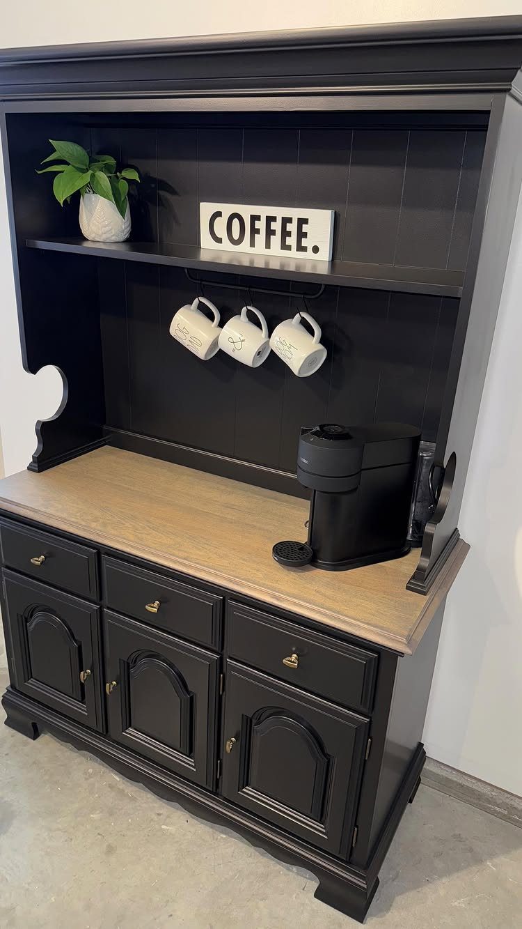 Black painted hutch repurposed as a coffee station with mugs and a coffee machine.