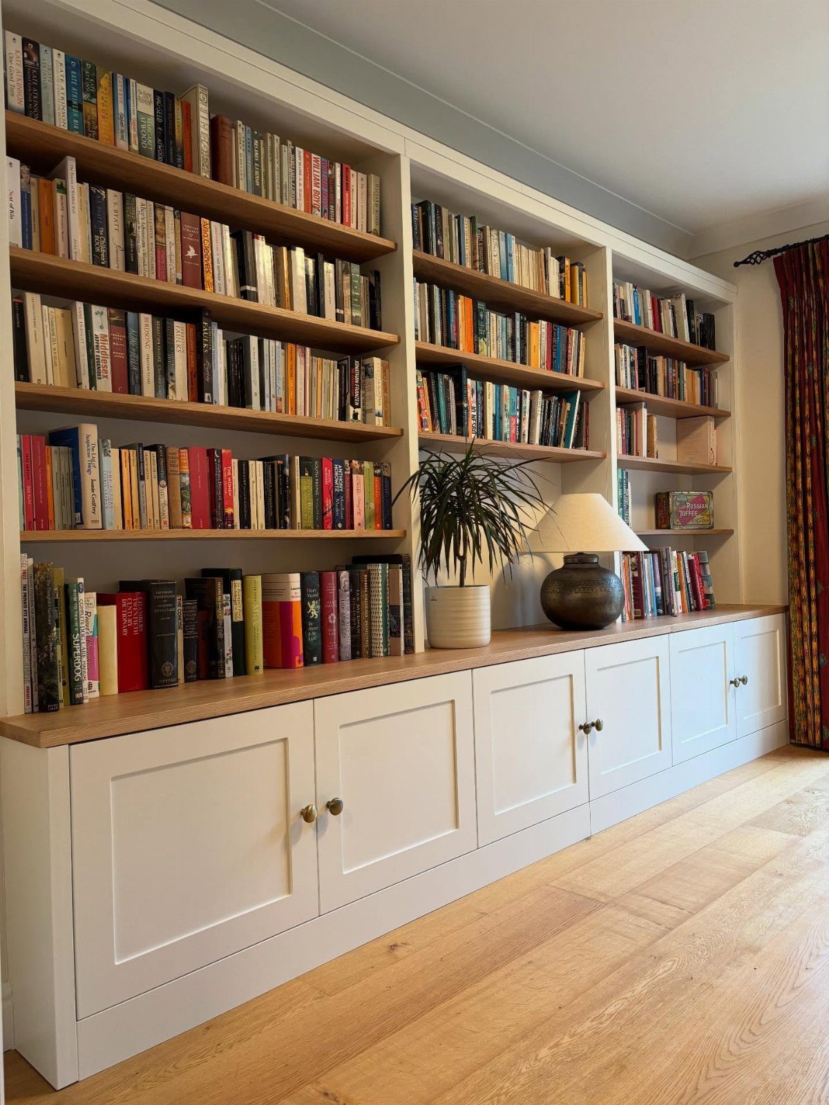 Furniture Plans Free for 16 Tables, Beds and Benches 3 White built-in bookcase with wooden shelves and lower shaker cabinets filled with books.