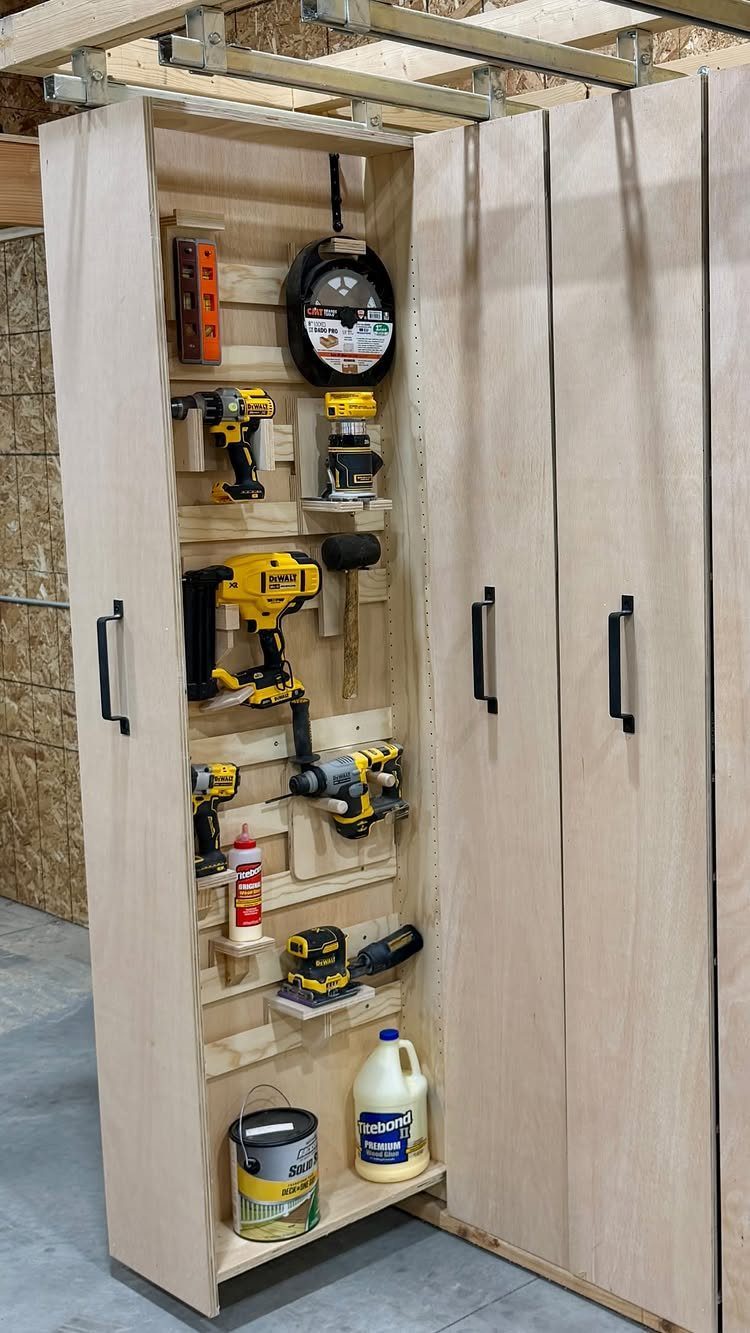 Wooden storage cabinet with power tools organized on the inside of the door.