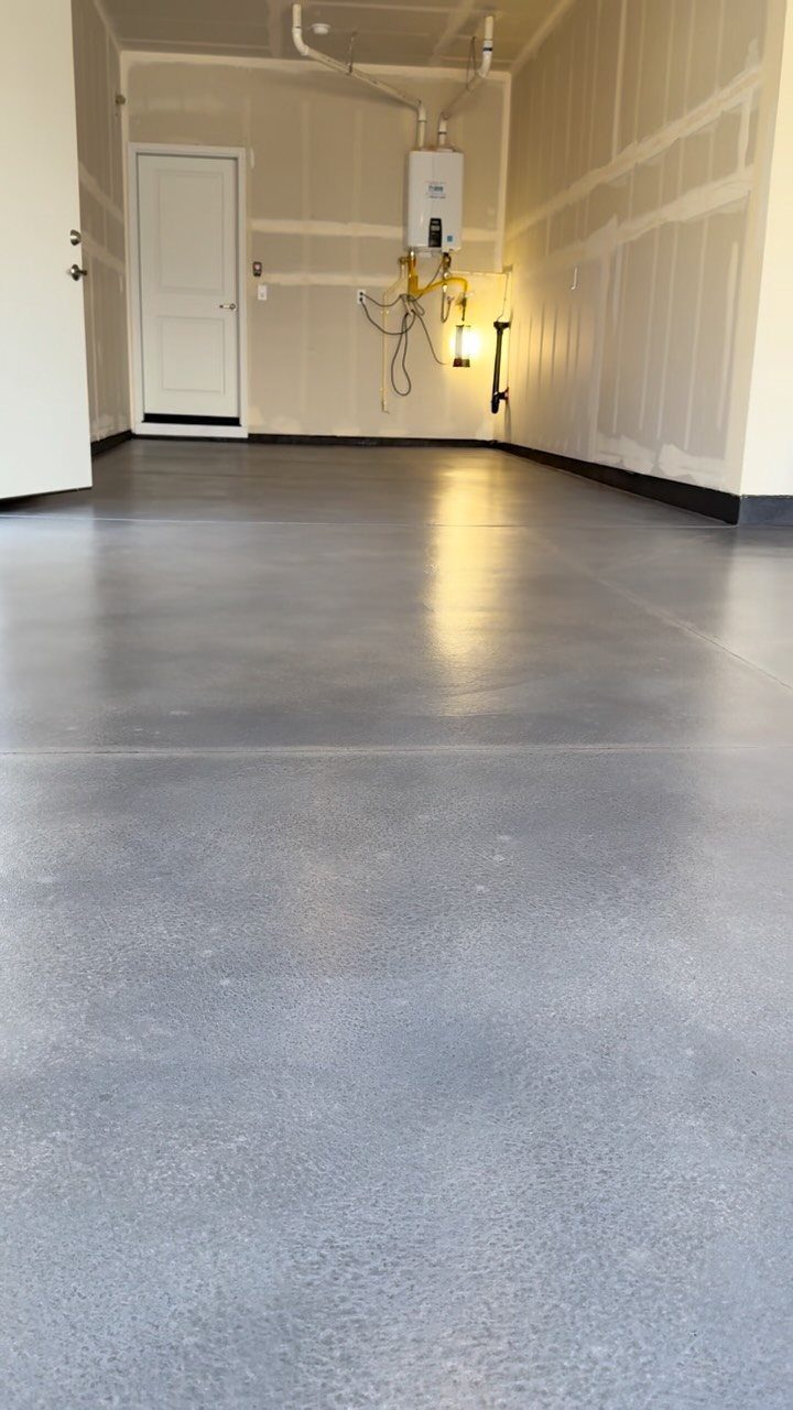 18 Garage Woodshop Ideas for Storage, Power, and Layout 11 Grey epoxy floor coating in a clean, empty garage with white walls.