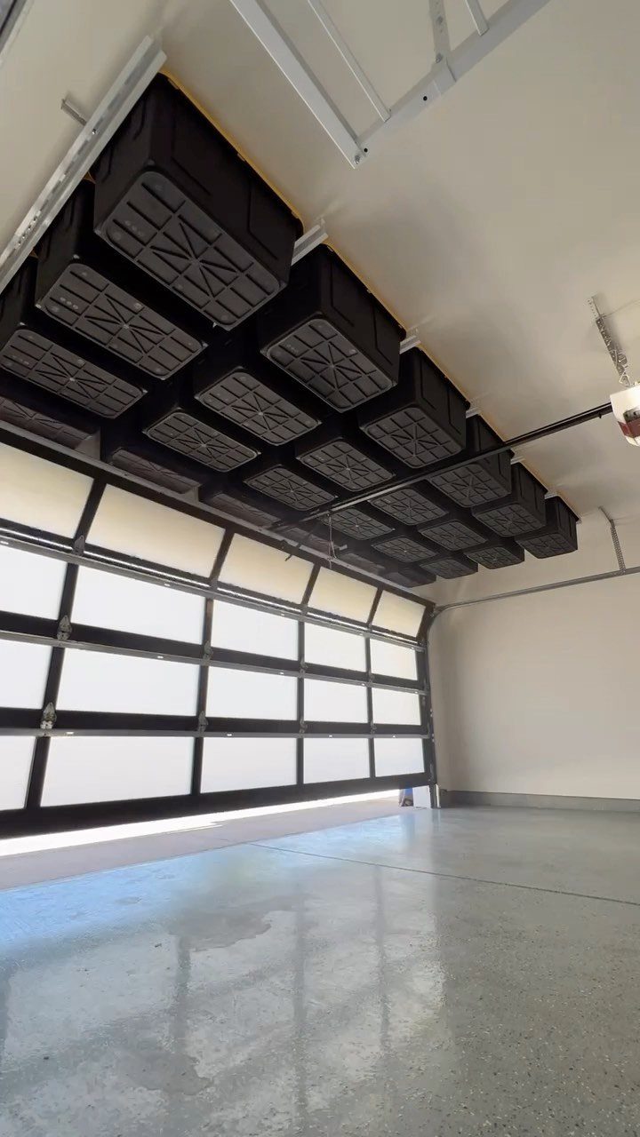 18 Garage Woodshop Ideas for Storage, Power, and Layout 2 Black storage bins in metal racks mounted to a white garage ceiling.