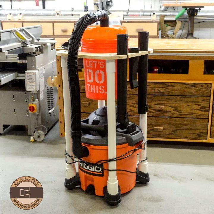 18 Garage Woodshop Ideas for Storage, Power, and Layout 12 Orange Ridgid shop vacuum in a custom white wooden frame within a woodshop.