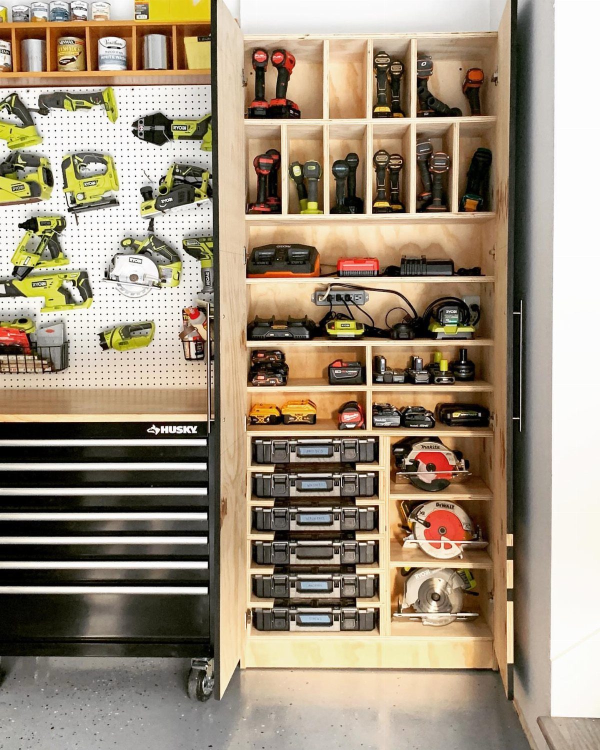 18 Garage Woodshop Ideas for Storage, Power, and Layout 14 Black rolling tool chest and custom wooden storage cabinet filled with power tools.