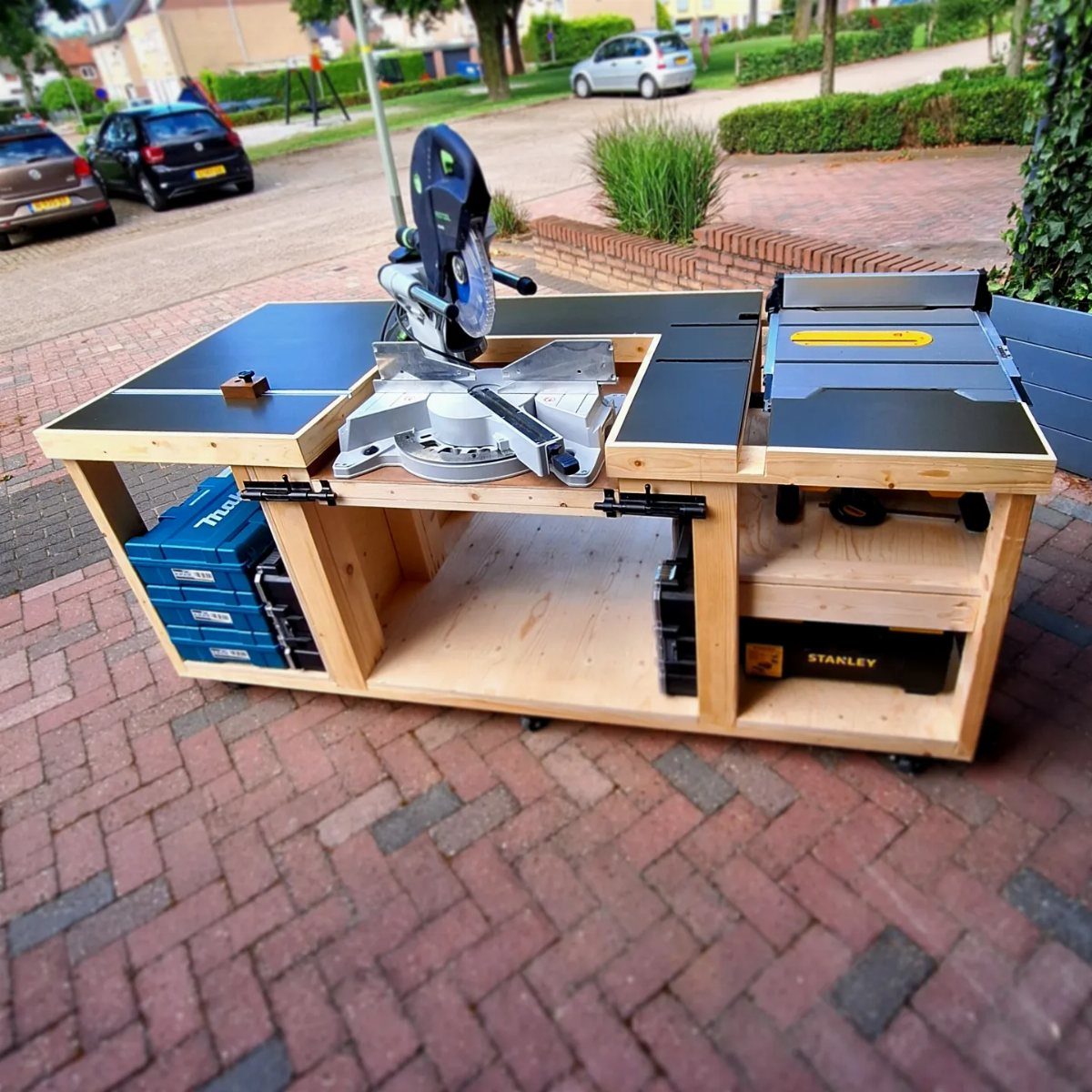 18 Garage Woodshop Ideas for Storage, Power, and Layout 10 Wooden workbench with integrated miter saw and table saw on a brick driveway.