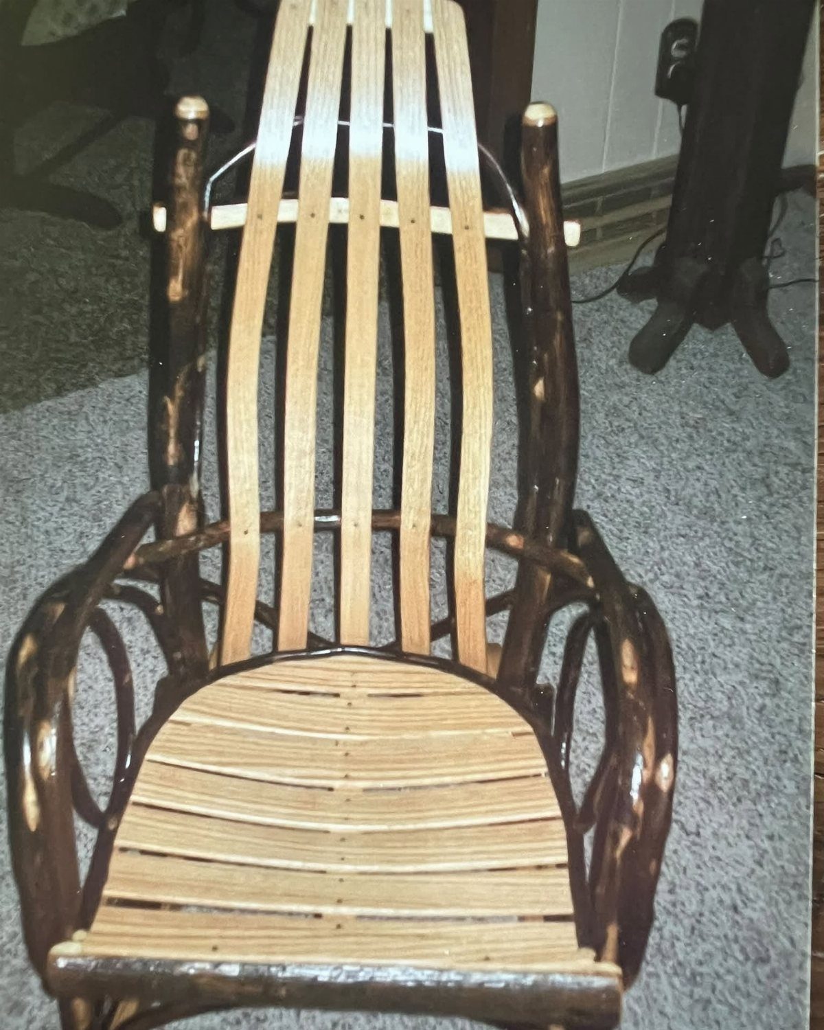 Wooden rocking chair crafted from dark natural branches and light wood slats.