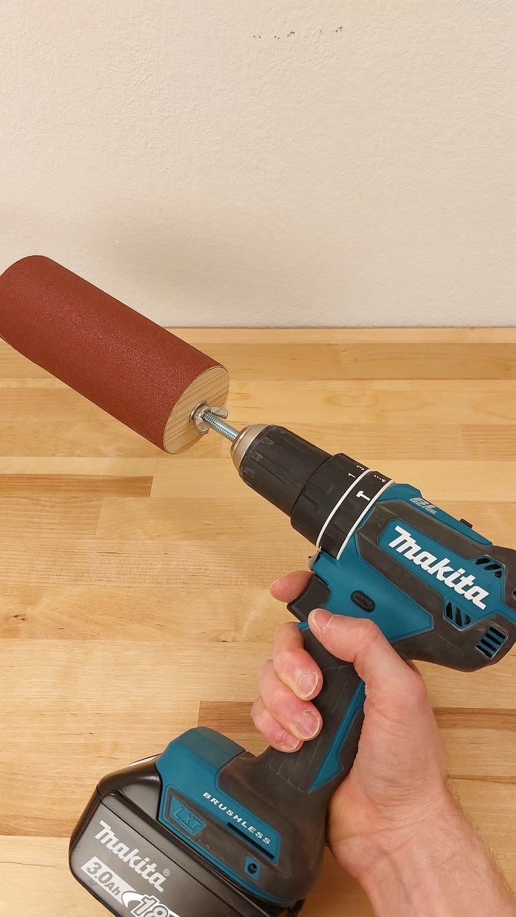 7 Homemade Tools for Woodworking You Can Build 2 Makita cordless drill with a homemade sanding drum attachment on a wooden workbench.