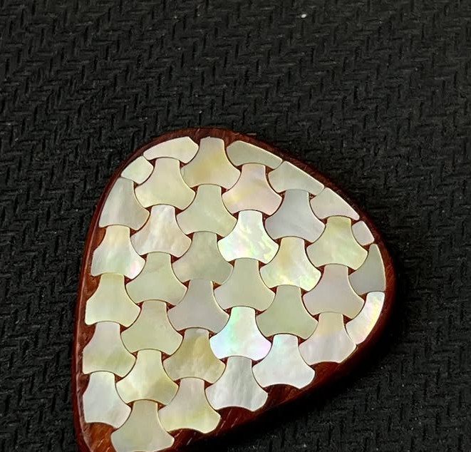 Inlays in Wood: 9 Ideas for Veneer, Resin and Metal 4 Wooden guitar pick with iridescent white mother-of-pearl geometric inlays on a black background
