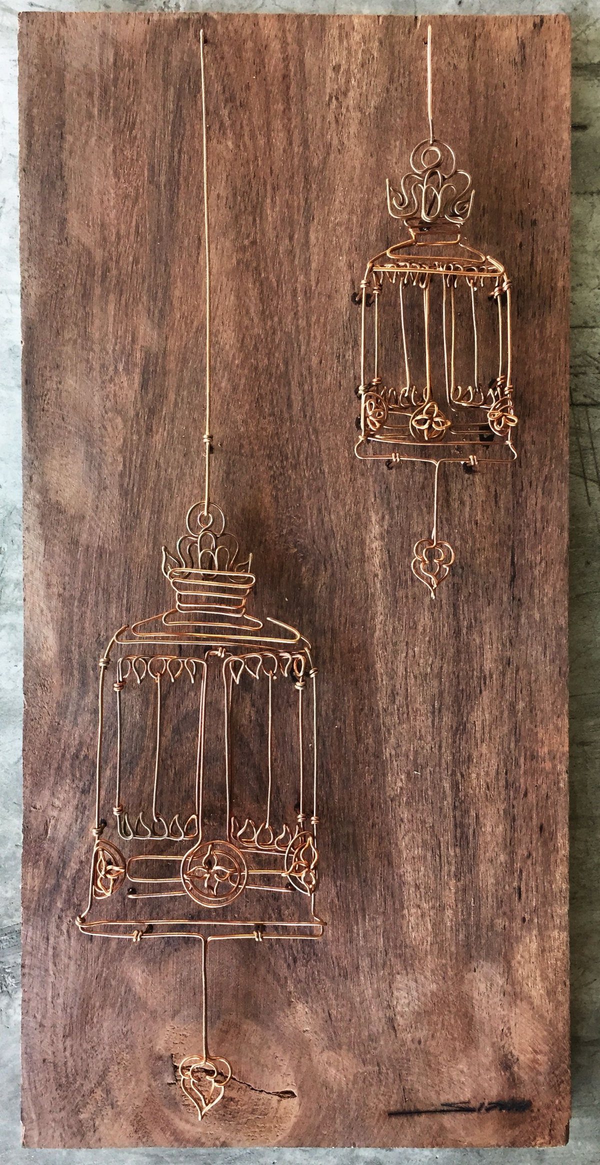 Inlays in Wood: 9 Ideas for Veneer, Resin and Metal 6 Copper-colored metal wire birdcages embedded into a brown wooden plank.
