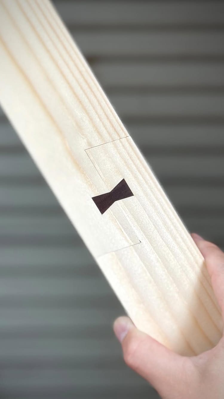 Wooden plank with a dark brown butterfly inlay stabilizing a natural crack.