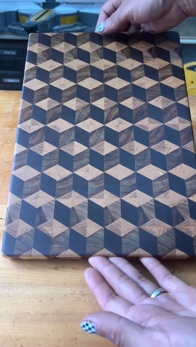 18 Kitchen Woodworking Projects for Storage and Gifts 11 Wooden cutting board with a 3D cube pattern held by two hands.