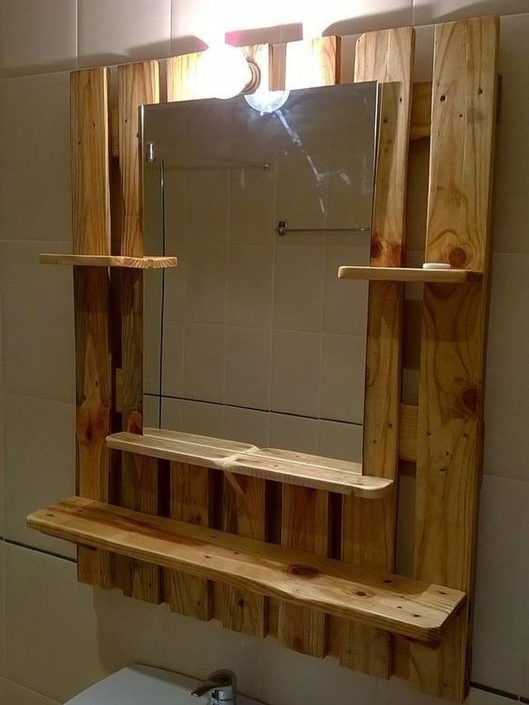 Rustic pallet wood mirror frame with integrated wooden shelves mounted on a bathroom wall
