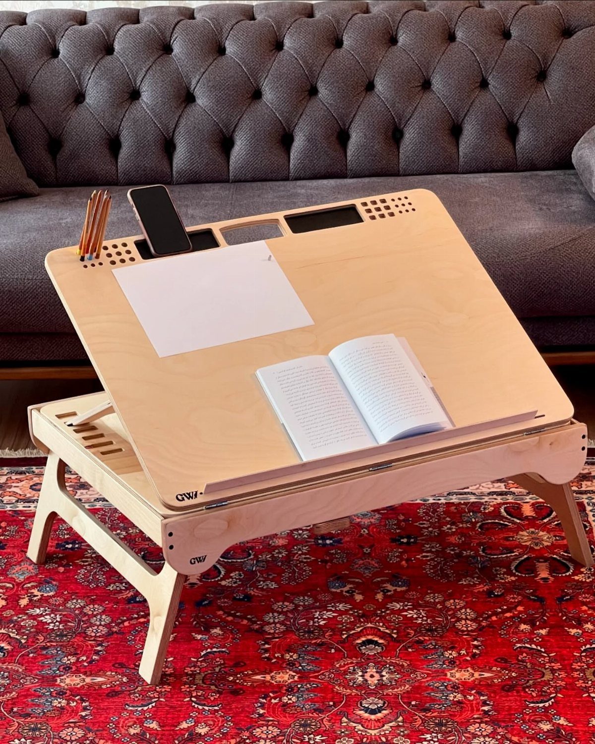 32 Mini Wood Projects for Beginners and Scrap Wood 21 Plywood lap desk with a book and phone on a red patterned rug.