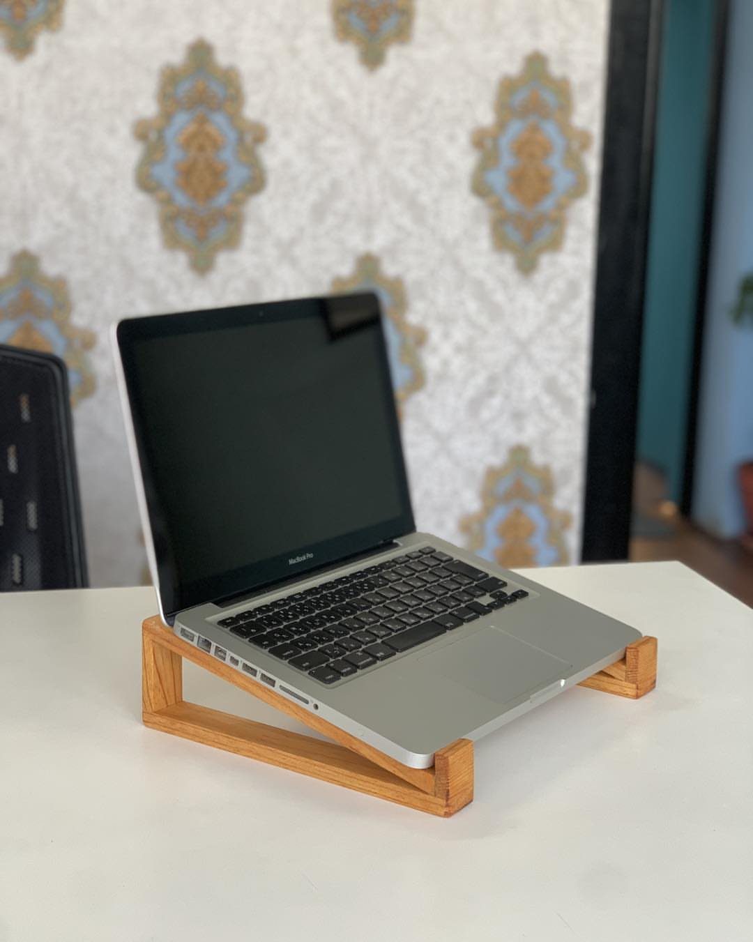 32 Mini Wood Projects for Beginners and Scrap Wood 11 Silver laptop resting on a light brown wooden stand on a white table