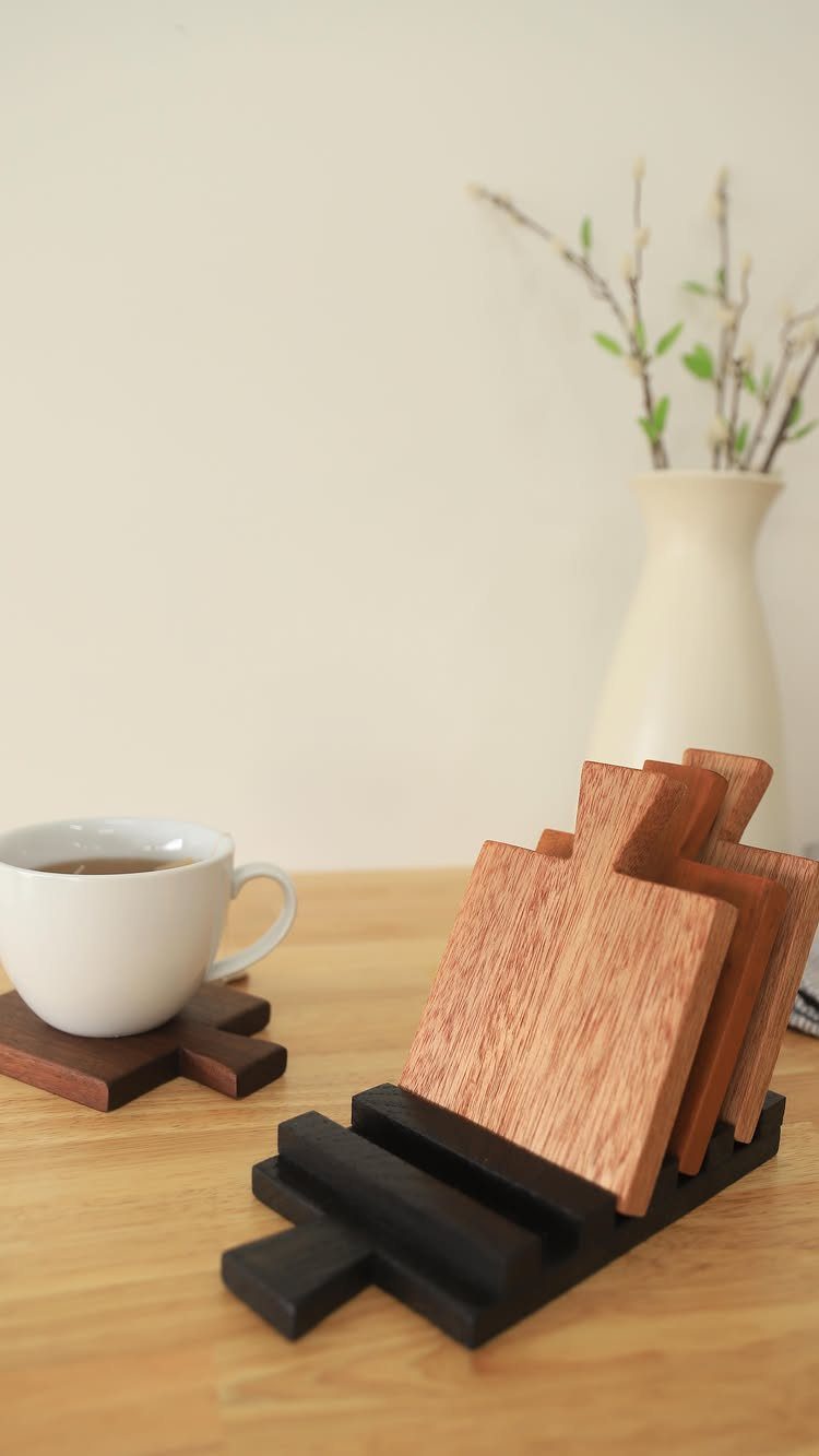32 Mini Wood Projects for Beginners and Scrap Wood 18 Wooden coasters in a holder with a white tea cup on a table.
