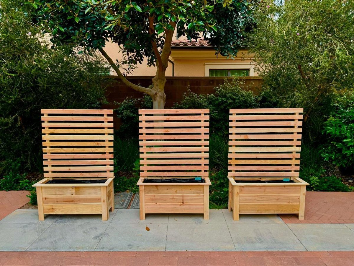 32 Mini Wood Projects for Beginners and Scrap Wood 27 Three wooden planter boxes with tall slatted trellises in a lush green garden.