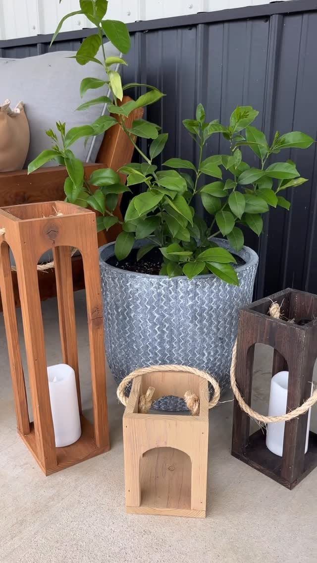 32 Mini Wood Projects for Beginners and Scrap Wood 12 Three wooden lanterns with white candles next to a potted green plant.