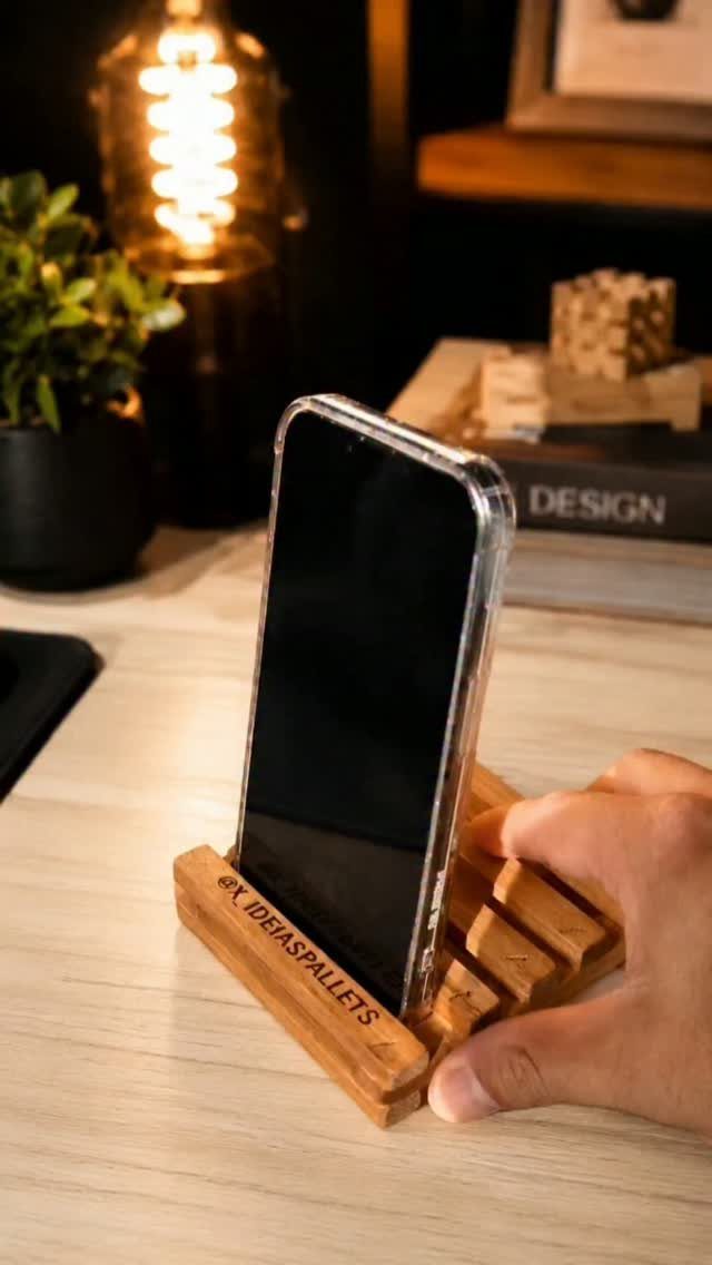32 Mini Wood Projects for Beginners and Scrap Wood 19 Smartphone resting in a small wooden phone holder on a desk with warm lighting.