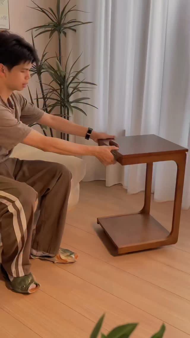 32 Mini Wood Projects for Beginners and Scrap Wood 28 Man kneeling next to a small dark brown wooden side table with a shelf.