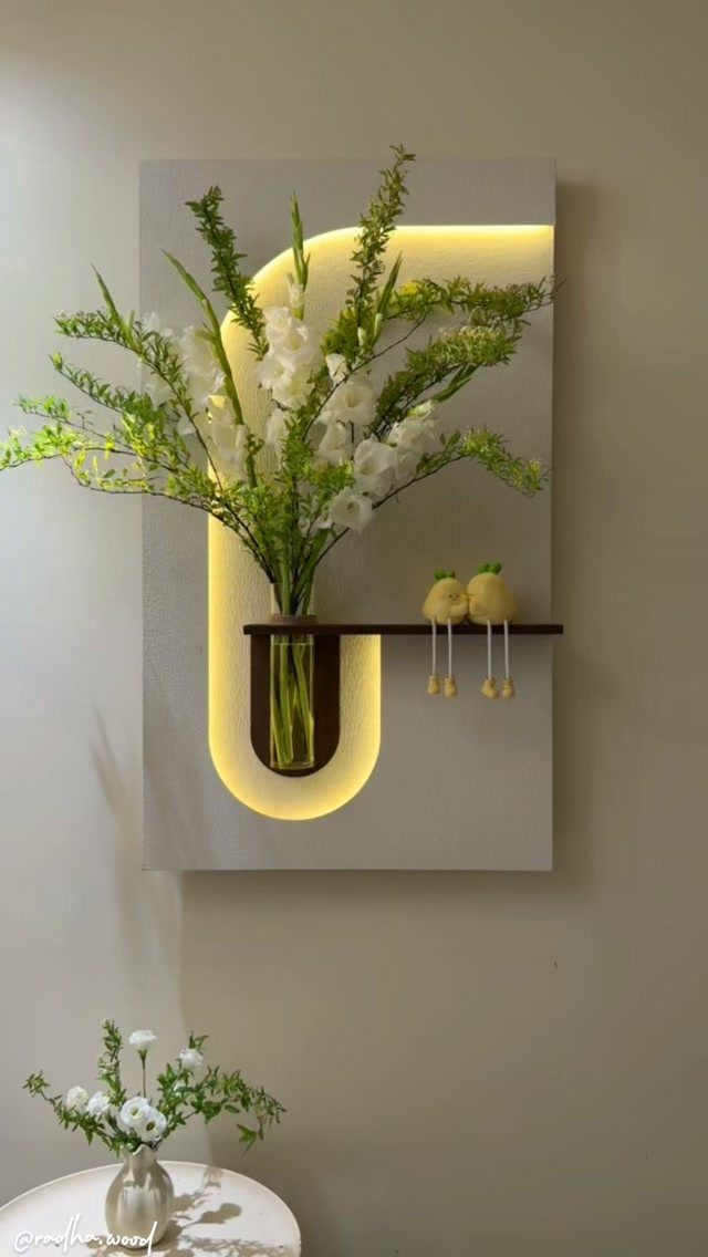32 Mini Wood Projects for Beginners and Scrap Wood 4 Modern wooden wall art with integrated lighting, a small shelf, and white flowers.