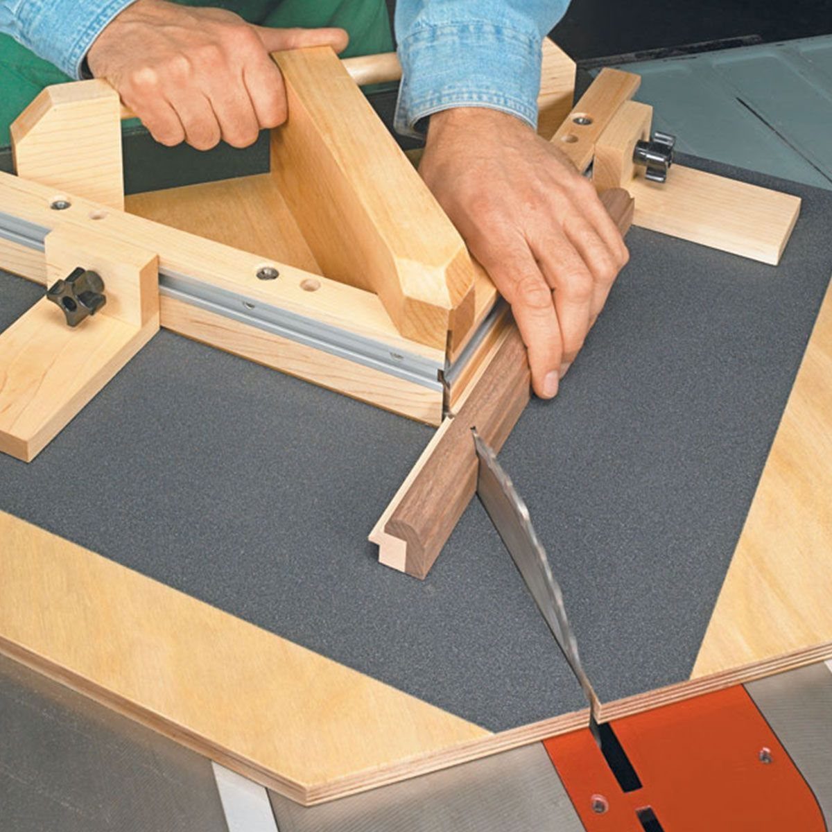 Mitered Corners for Wood: 4 Ideas for Tight Joints 4 Hands using a wooden miter sled to cut a piece of trim on a table saw