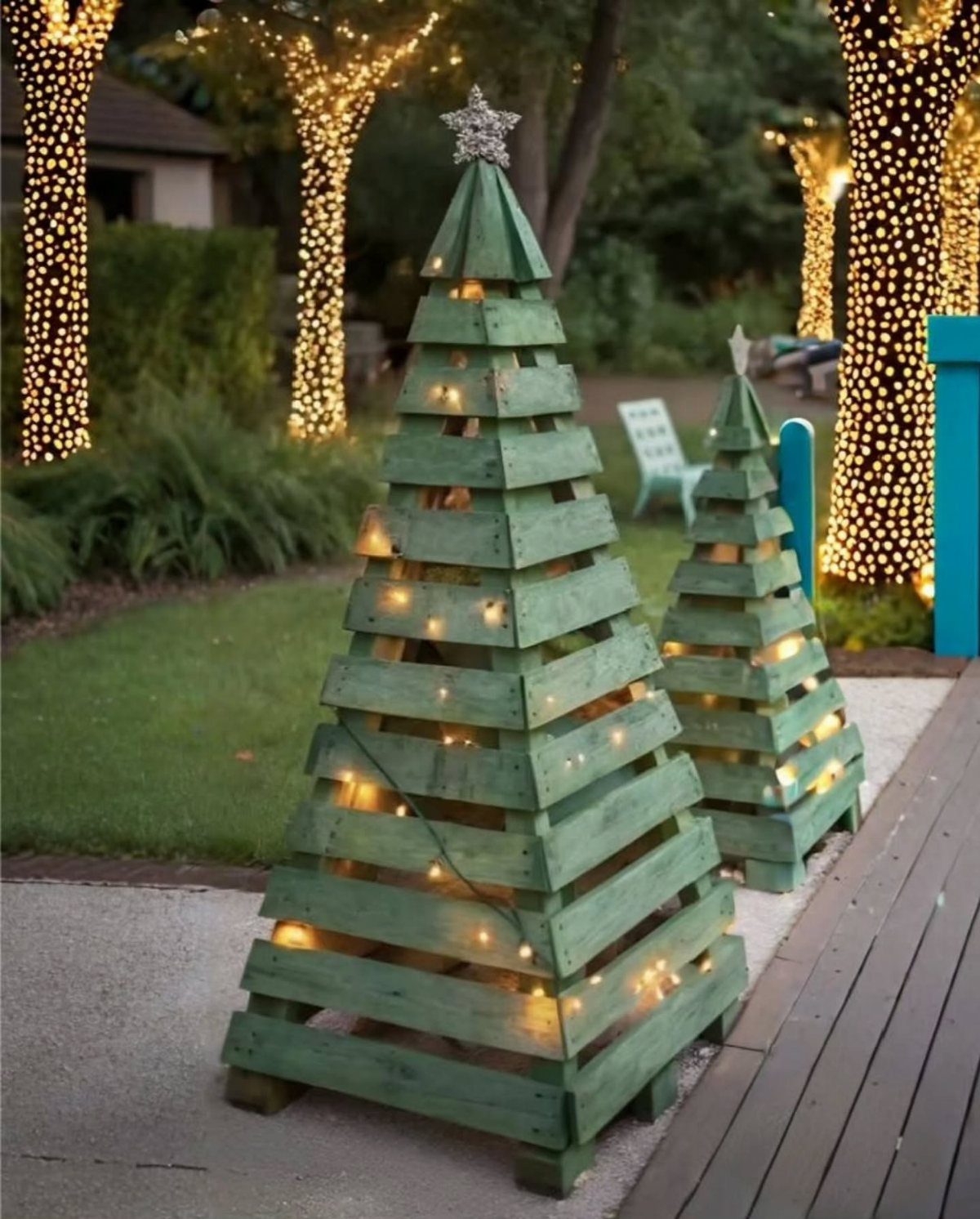 21 Pallet Wood DIY Projects for Home, Holidays and Yard 13 Two green pallet wood Christmas trees with fairy lights on an outdoor path.
