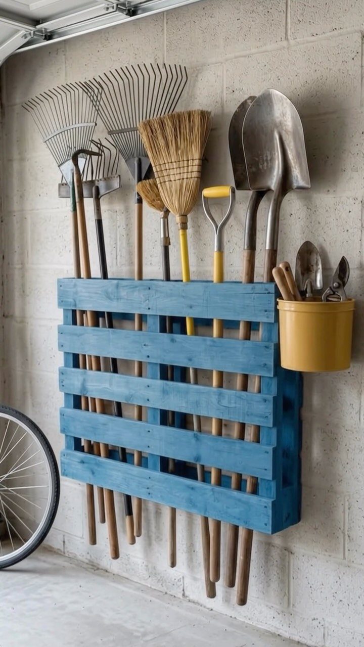21 Pallet Wood DIY Projects for Home, Holidays and Yard 15 Blue painted pallet wood tool organizer holding rakes and shovels on a garage wall