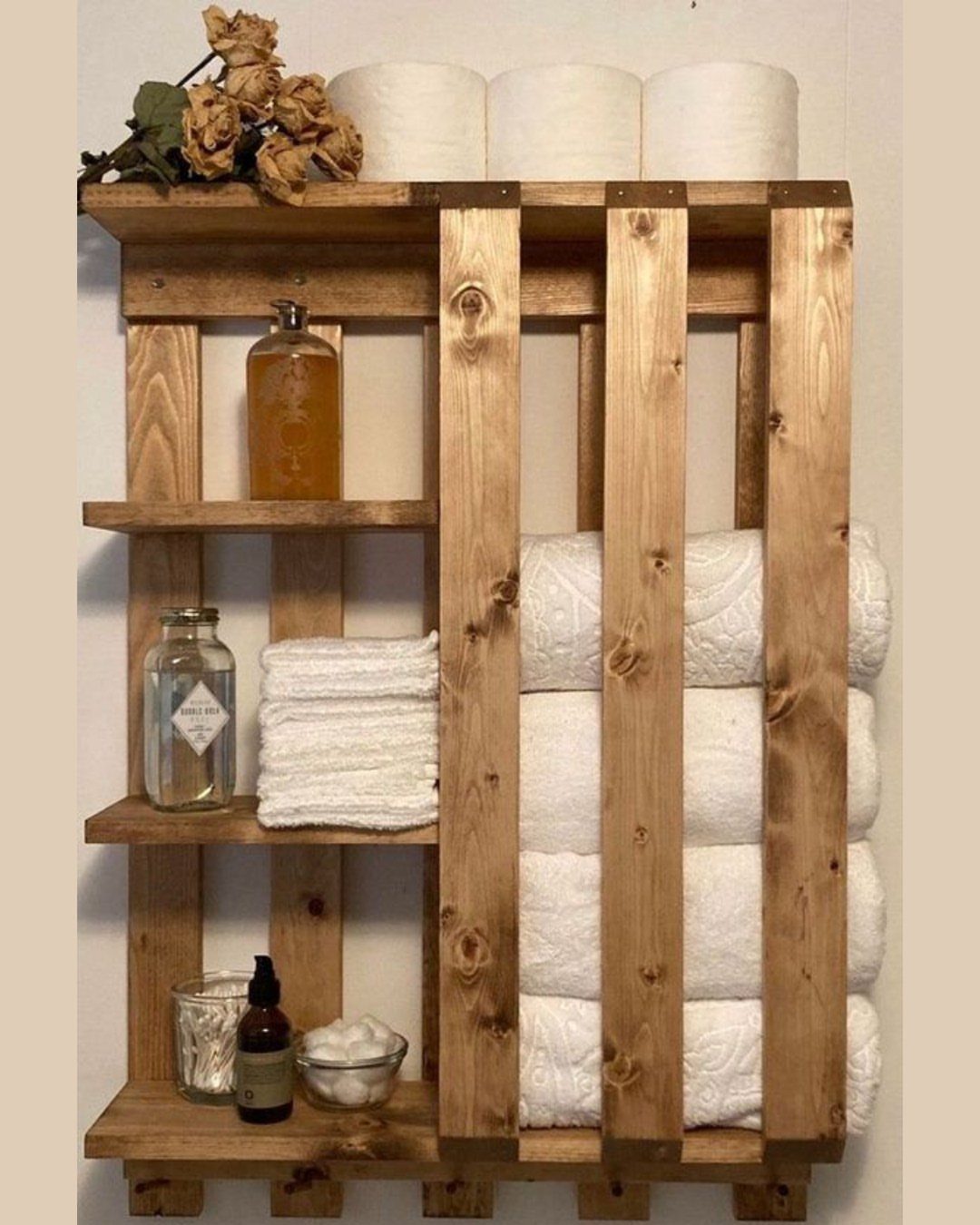 21 Pallet Wood DIY Projects for Home, Holidays and Yard 4 Rustic pallet wood towel rack with shelves holding white towels and bathroom accessories.