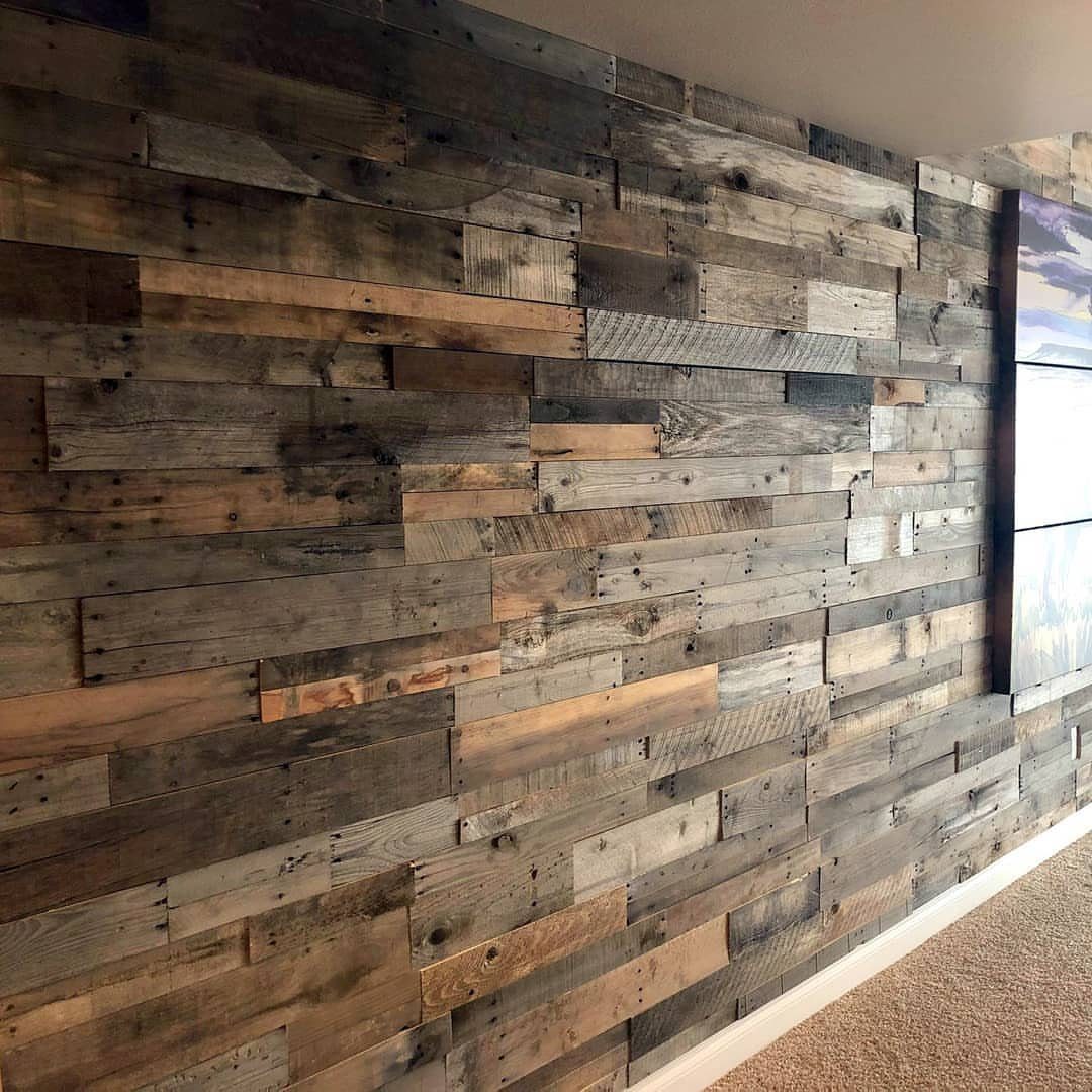 21 Pallet Wood DIY Projects for Home, Holidays and Yard 16 Reclaimed pallet wood planks arranged in a rustic accent wall with weathered tones.