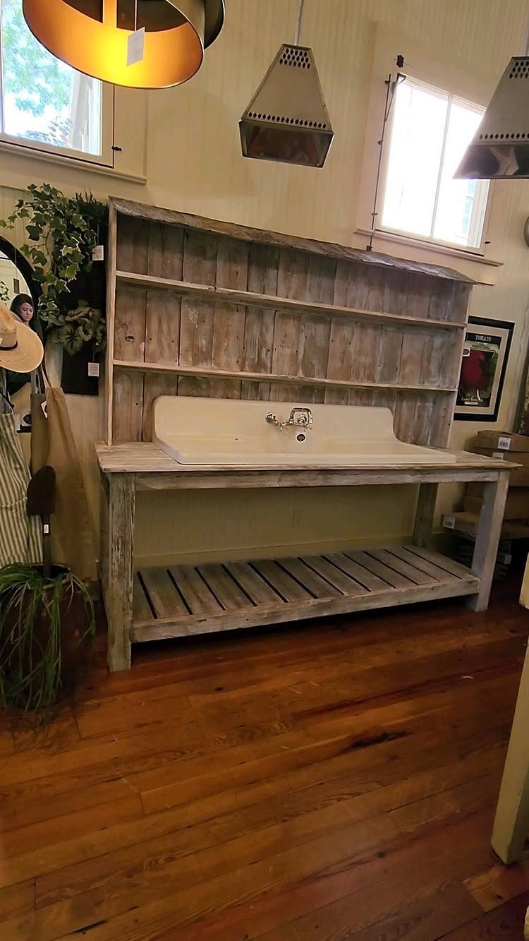 Rustic farmhouse potting bench with a white sink and slatted bottom shelf.