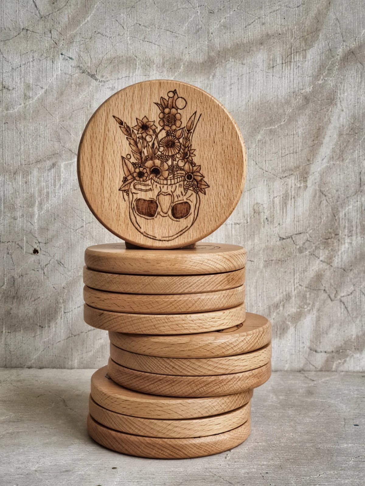 Pyrography Patterns Free to Try: 6 Wood Burning Ideas 2 Wood-burned coaster with a floral skull design stacked on plain wooden coasters.