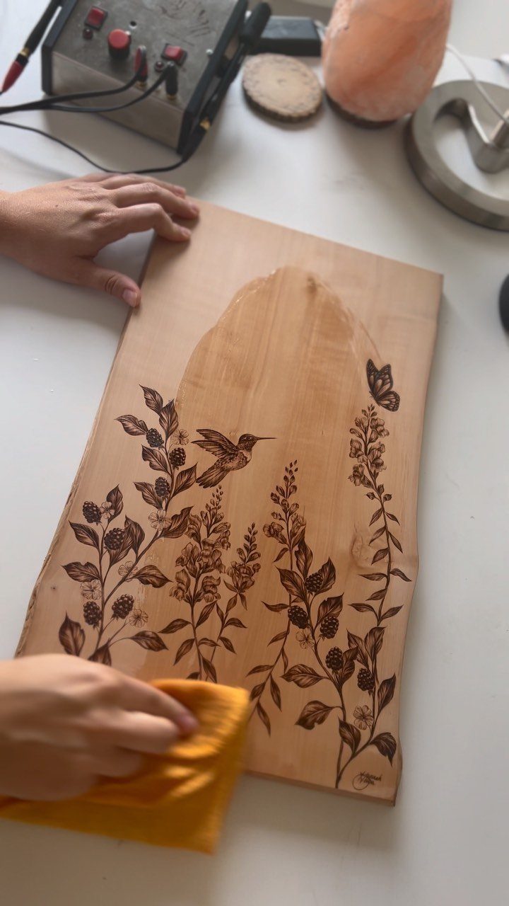 Pyrography Patterns Free to Try: 6 Wood Burning Ideas 6 Wood-burned hummingbird and floral design on a light wooden board being polished.